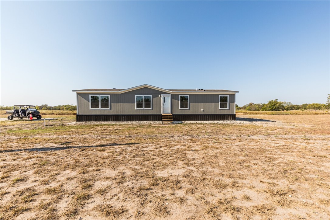 a view of house with yard and ocean view