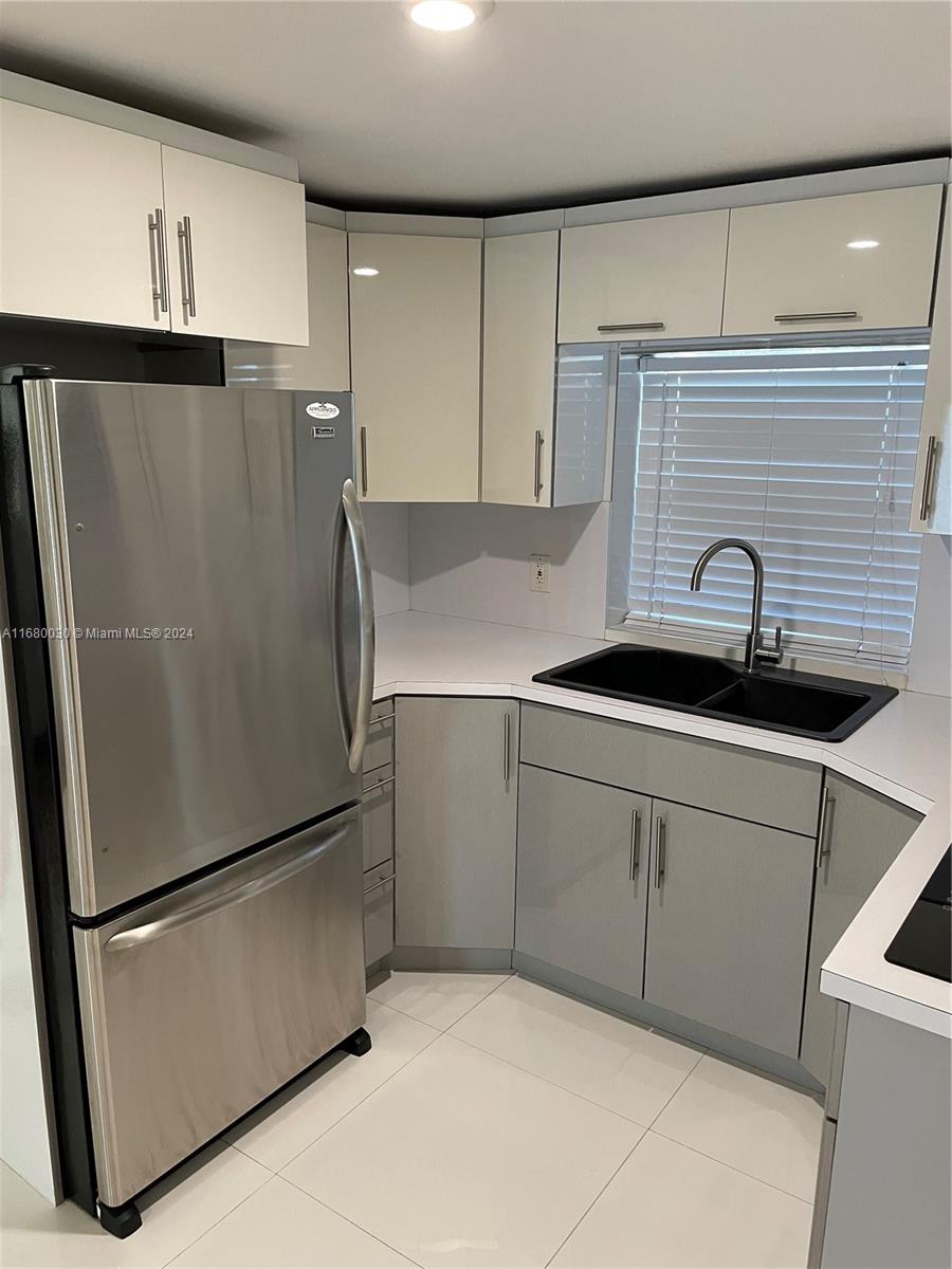 a kitchen with a refrigerator and a sink