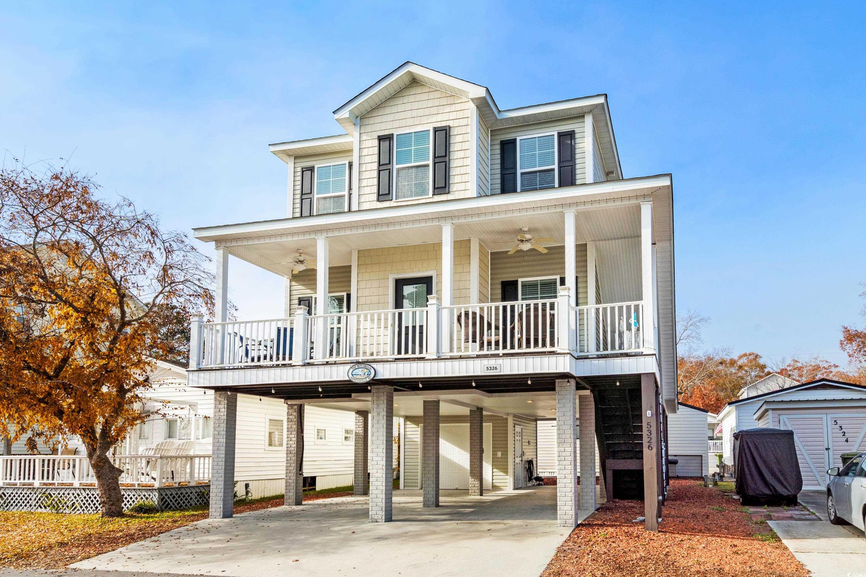 Coastal inspired home with a carport, covered porc