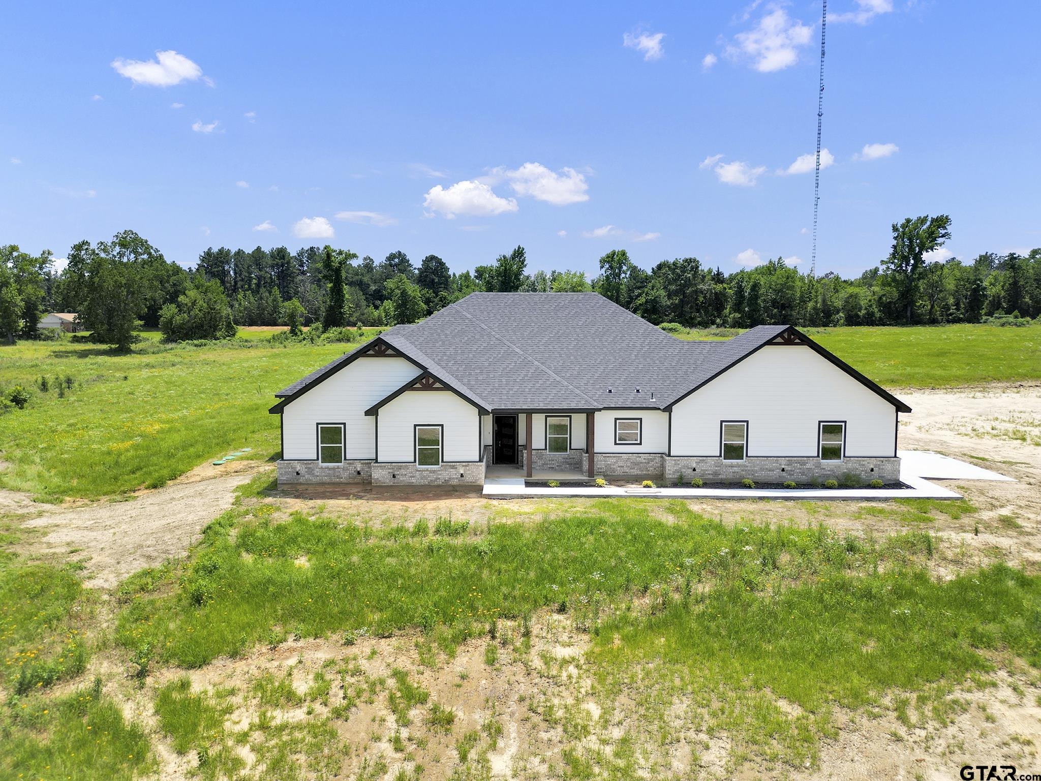 a house that is sitting in middle of the green field