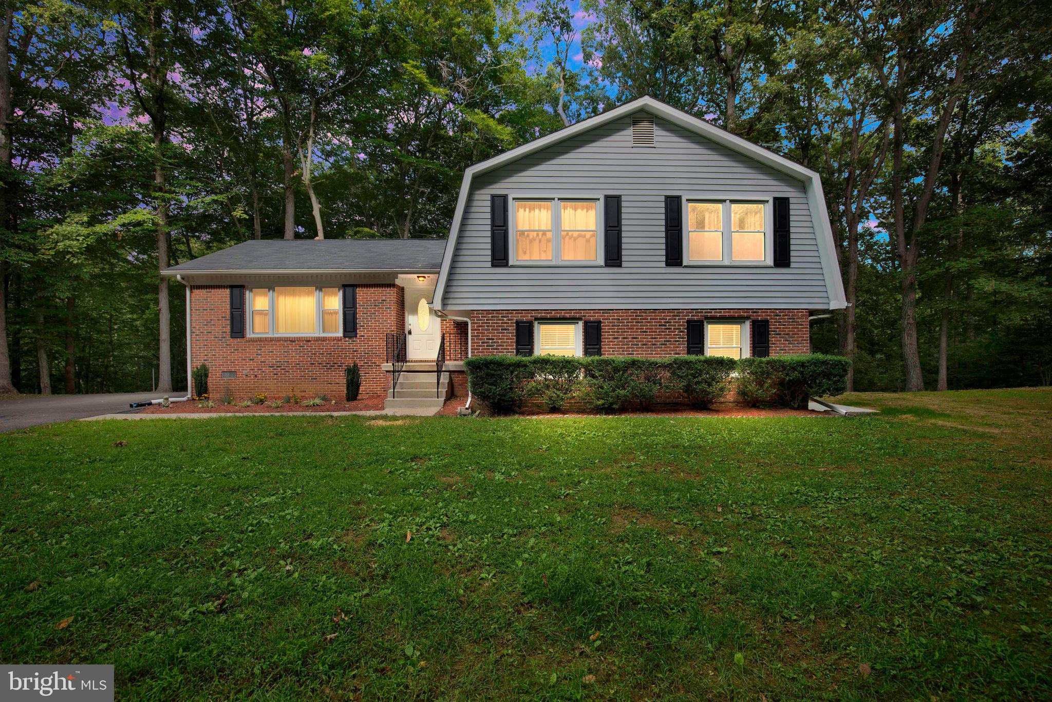 a front view of a house with a yard and trees