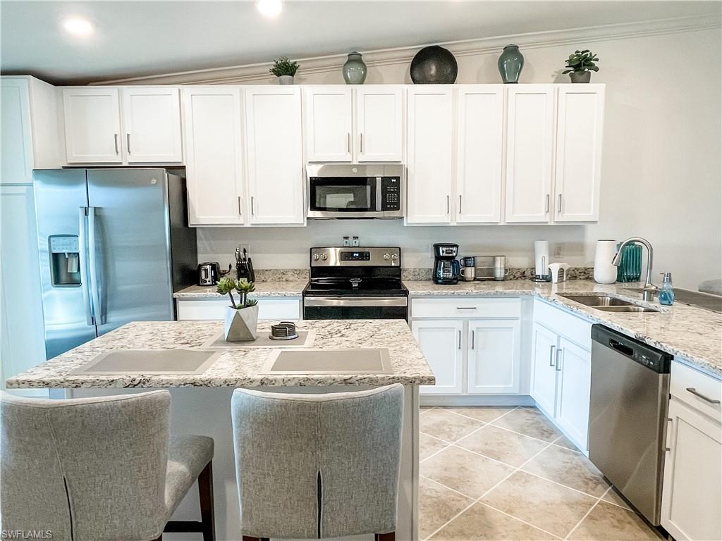 a kitchen with stainless steel appliances granite countertop a refrigerator sink and cabinets