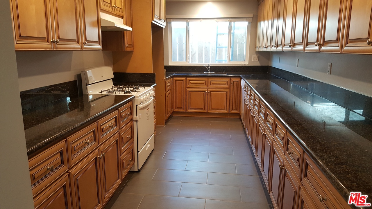 a kitchen with stainless steel appliances granite countertop a sink and a stove