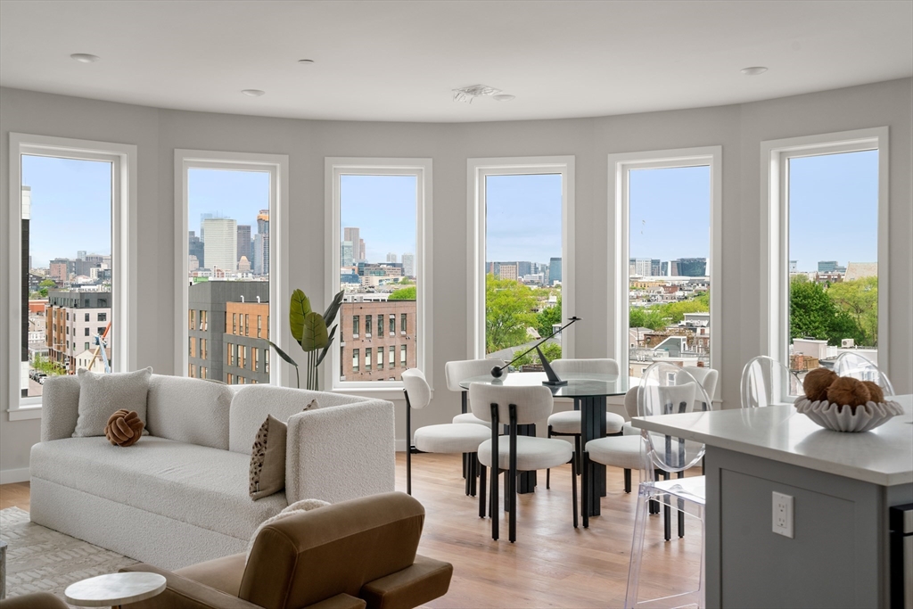 a living room with furniture wooden floor and a large window