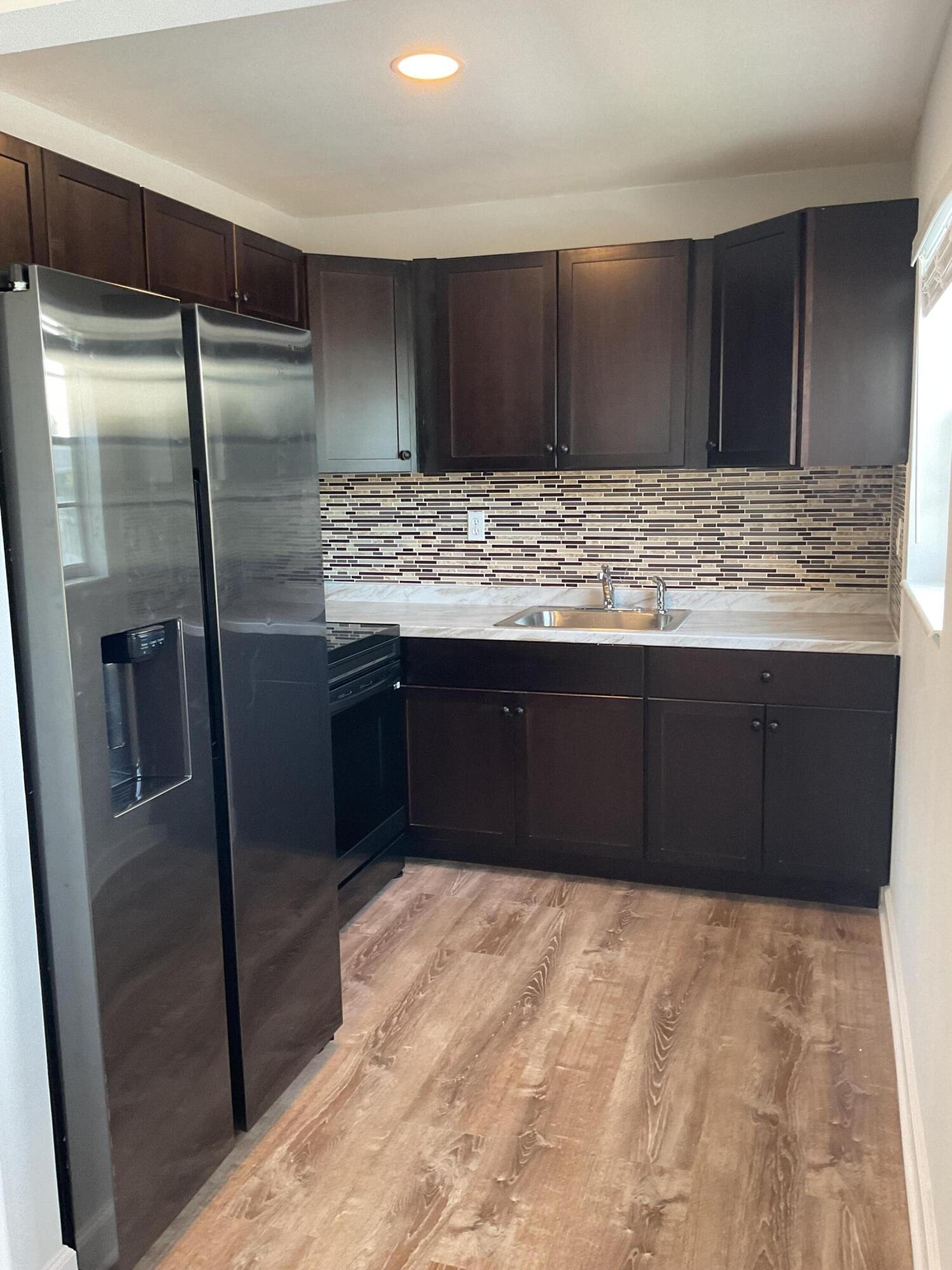 a kitchen with stainless steel appliances granite countertop a refrigerator and a sink