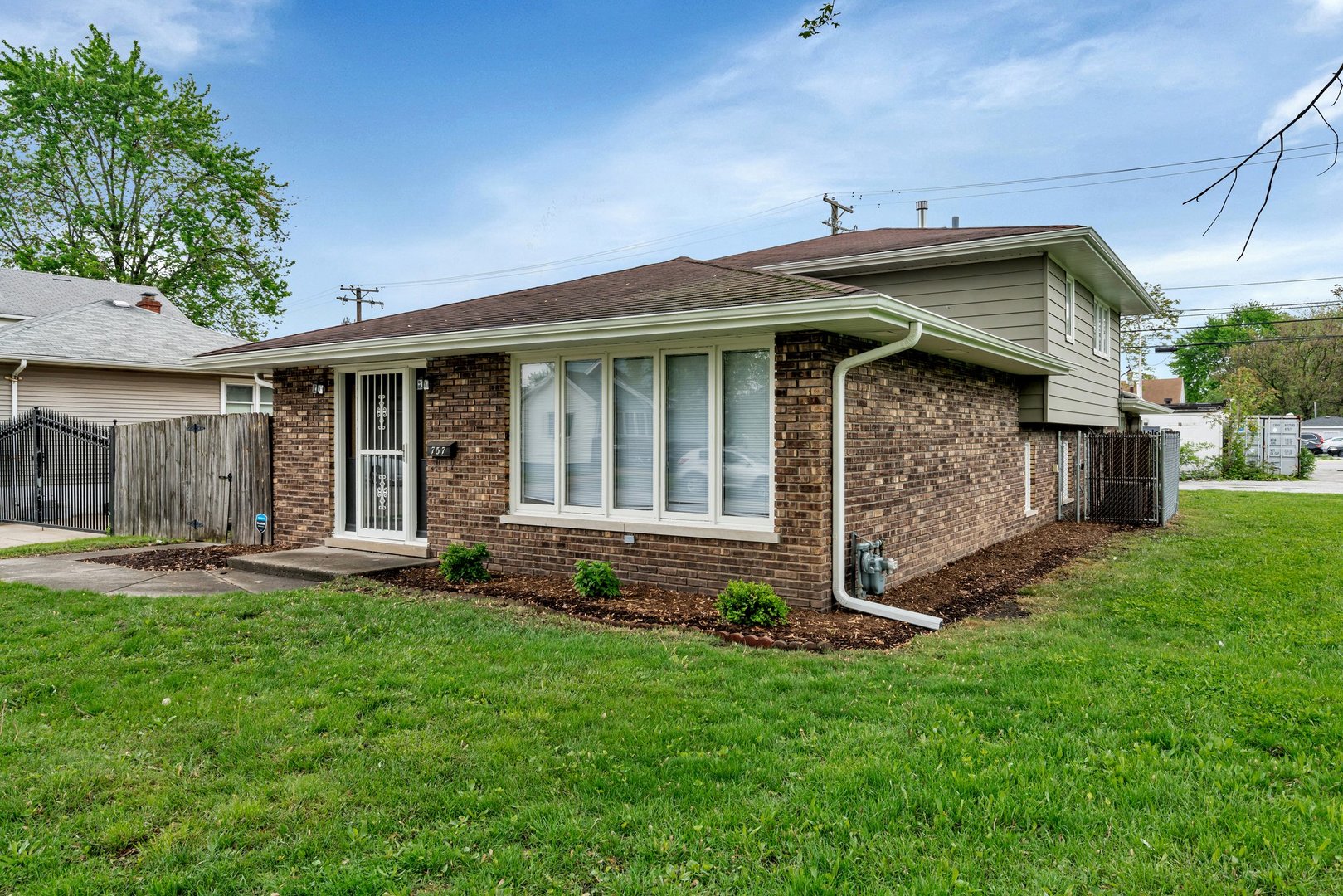 a front view of a house with a garden and yard