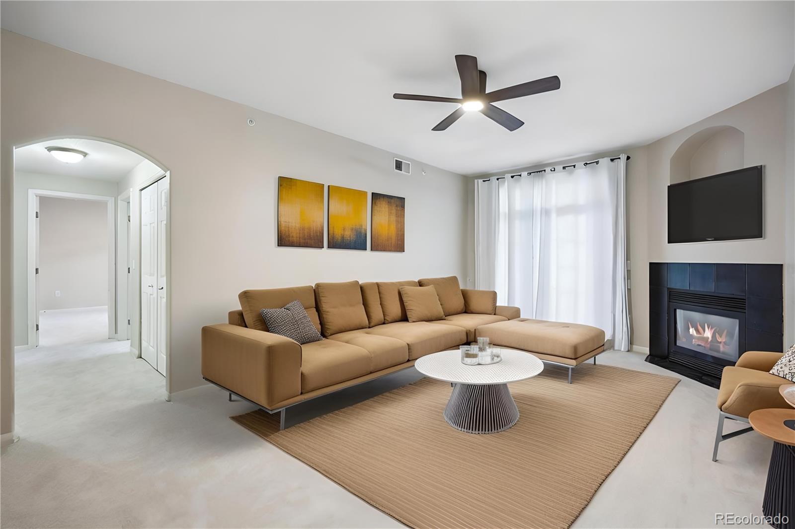 a living room with furniture a fireplace and a flat screen tv