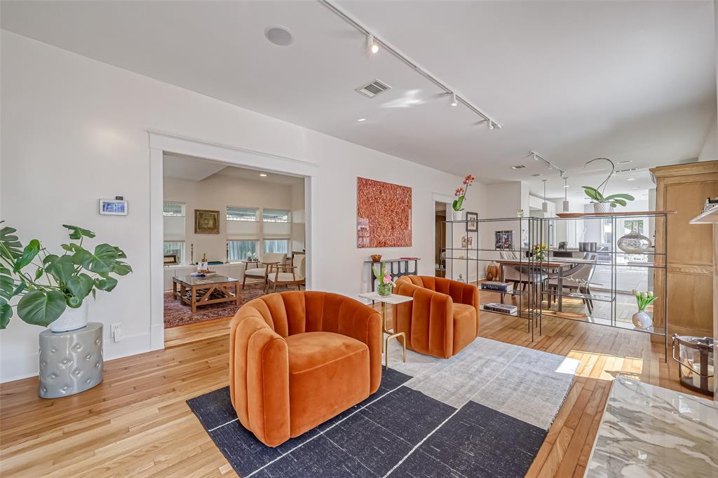 a living room with furniture potted plant and kitchen view