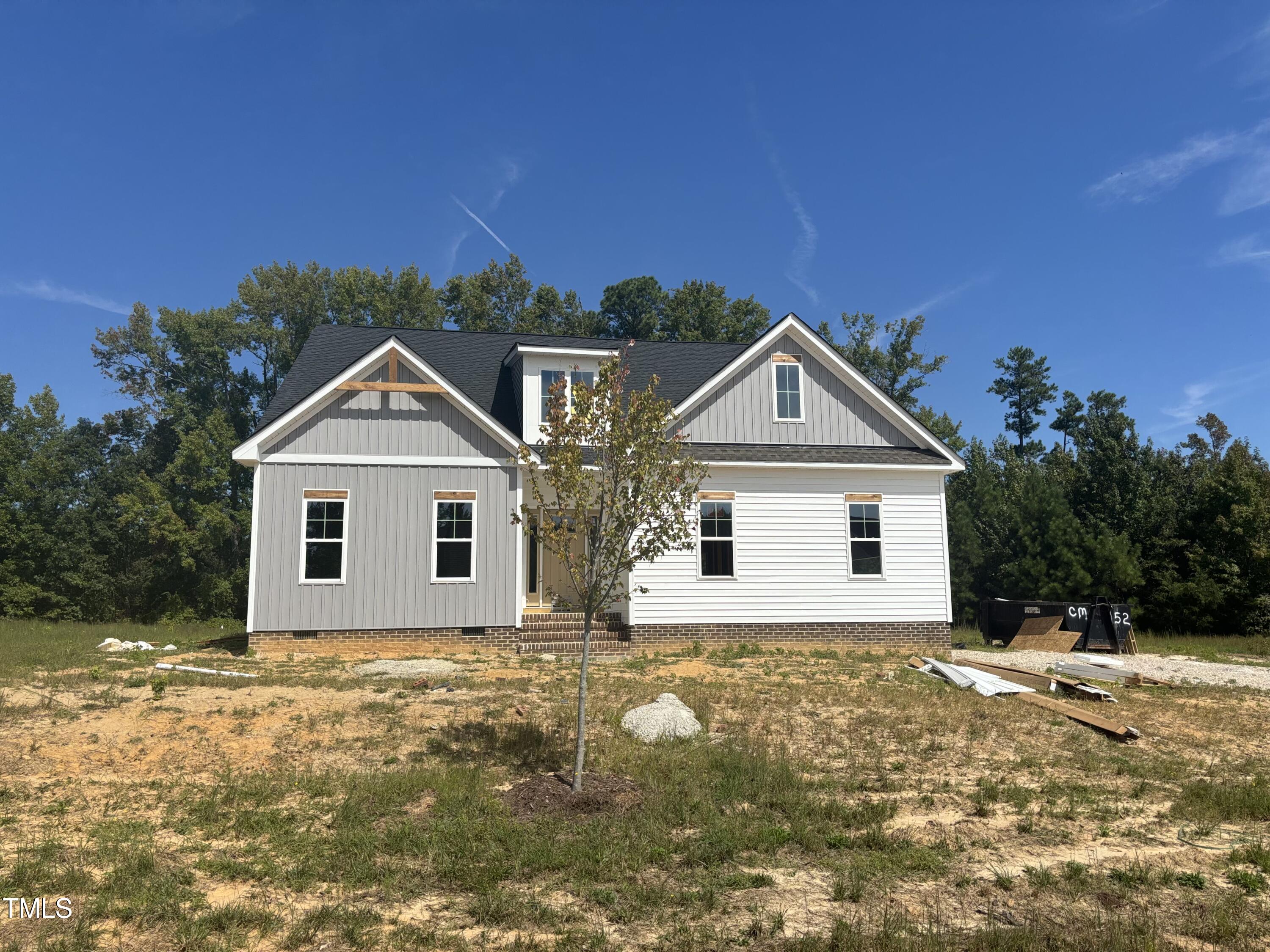 a front view of house with yard and trees in the background