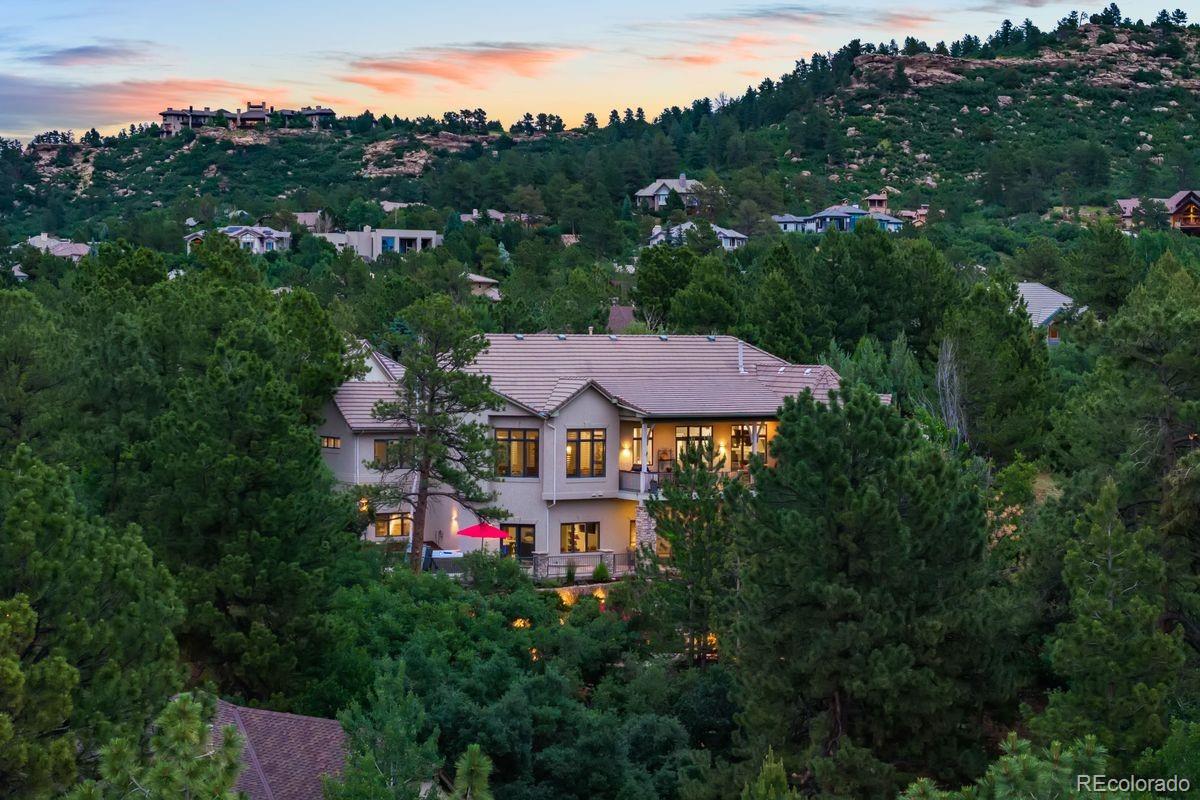 an aerial view of a house with a big yard and large trees