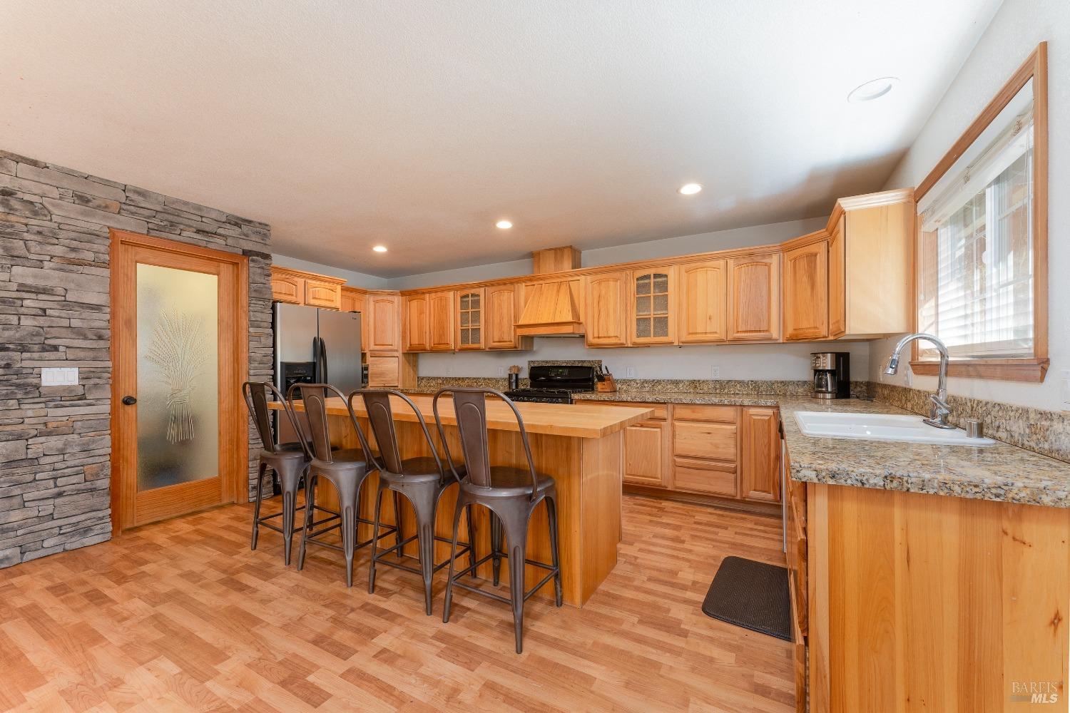 a kitchen with stainless steel appliances granite countertop sink refrigerator and cabinets