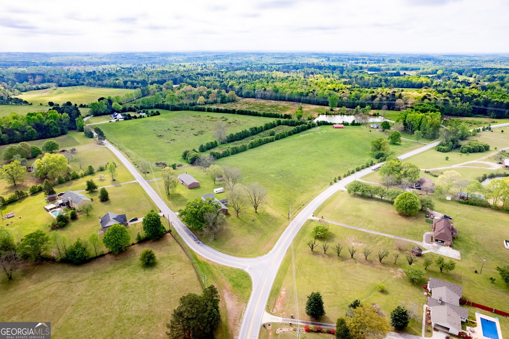 an aerial view of a house with a garden and lake view