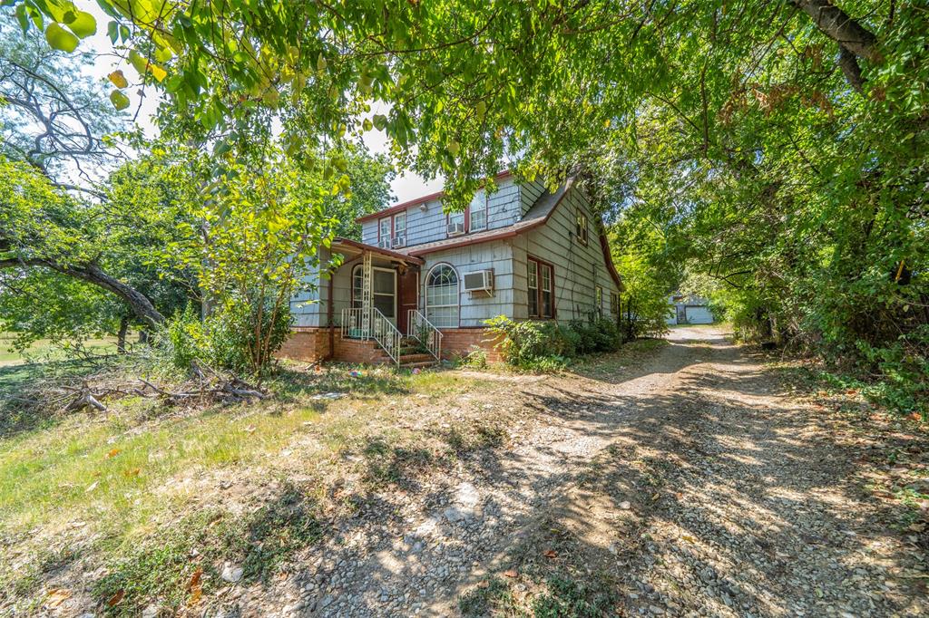 a view of a house with a tree in the yard