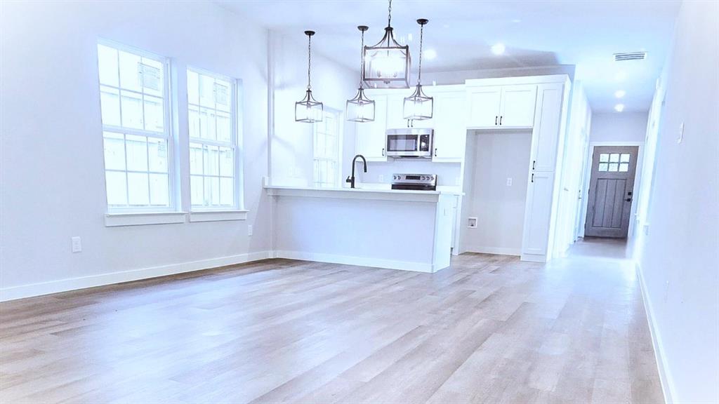 a kitchen with stainless steel appliances a refrigerator sink and microwave