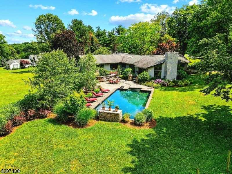 a view of a house with a big yard and large trees