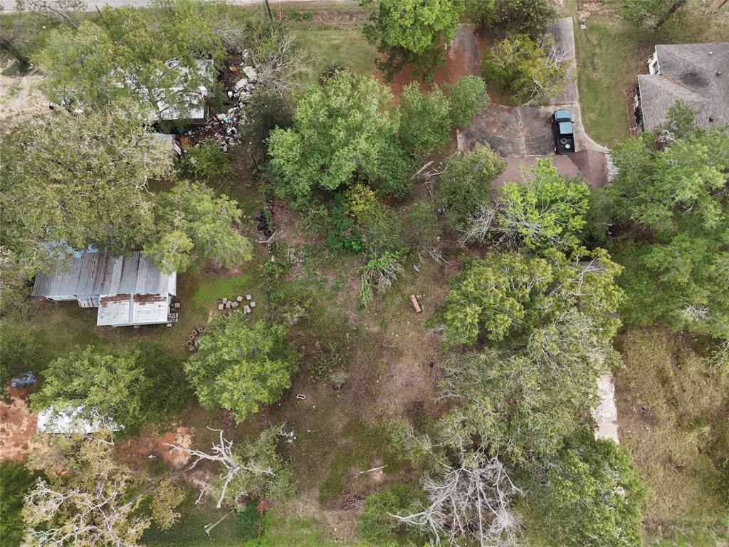 an aerial view of residential house with outdoor space and trees all around