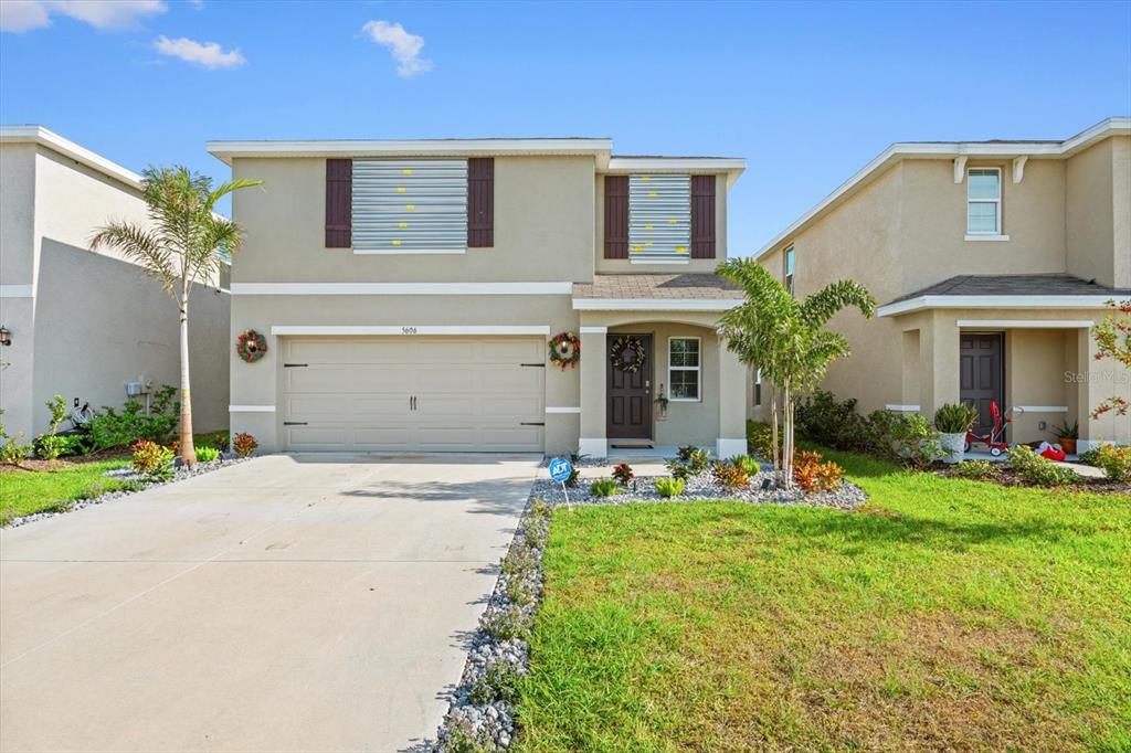 a front view of a house with a yard and garage