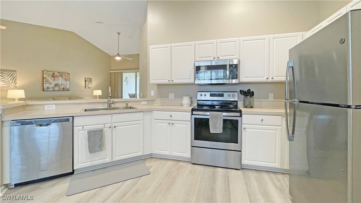 a kitchen with white cabinets and stainless steel appliances