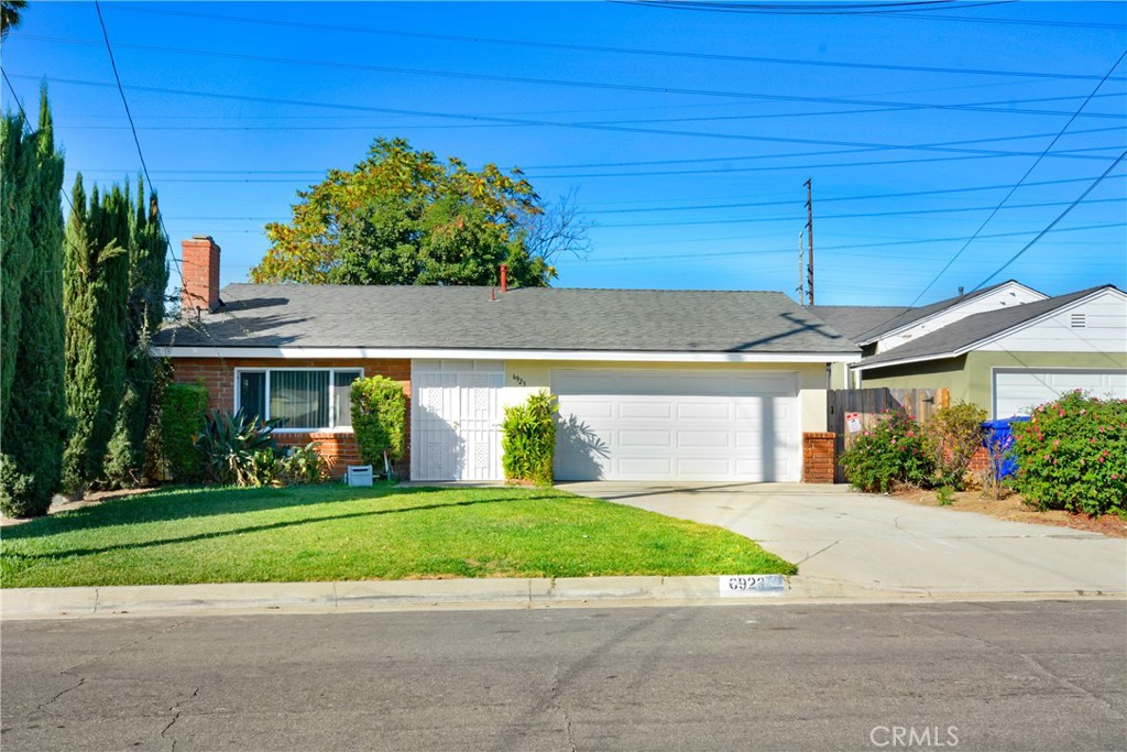 a front view of a house with a yard and potted plants