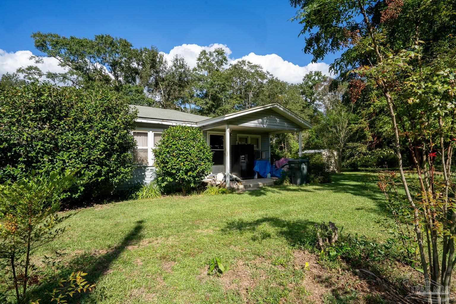 a view of a house with yard and sitting area