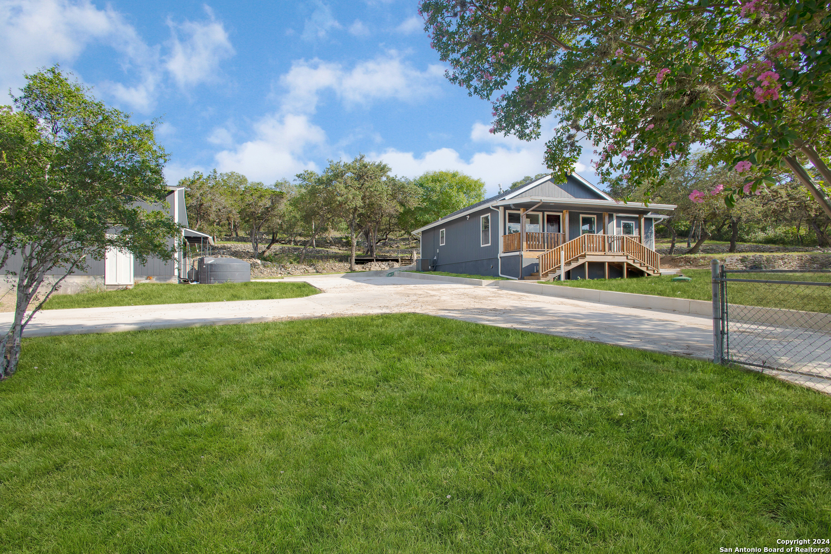 a view of a house with a big yard and a large tree