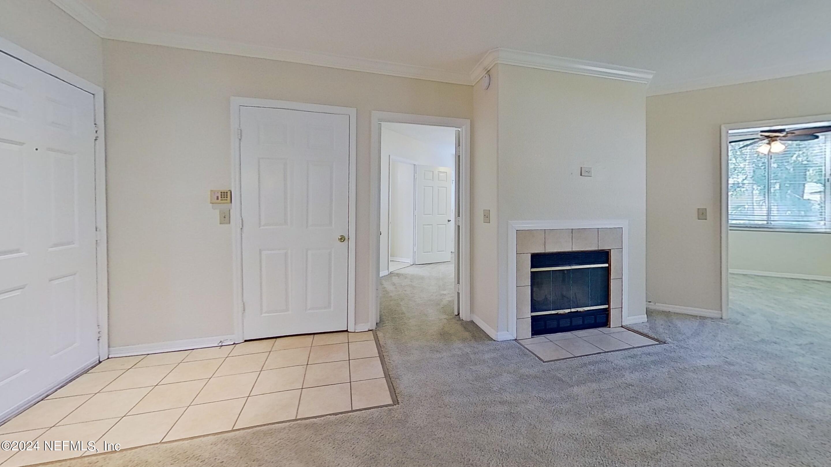 a view of an empty room with a fireplace and a window