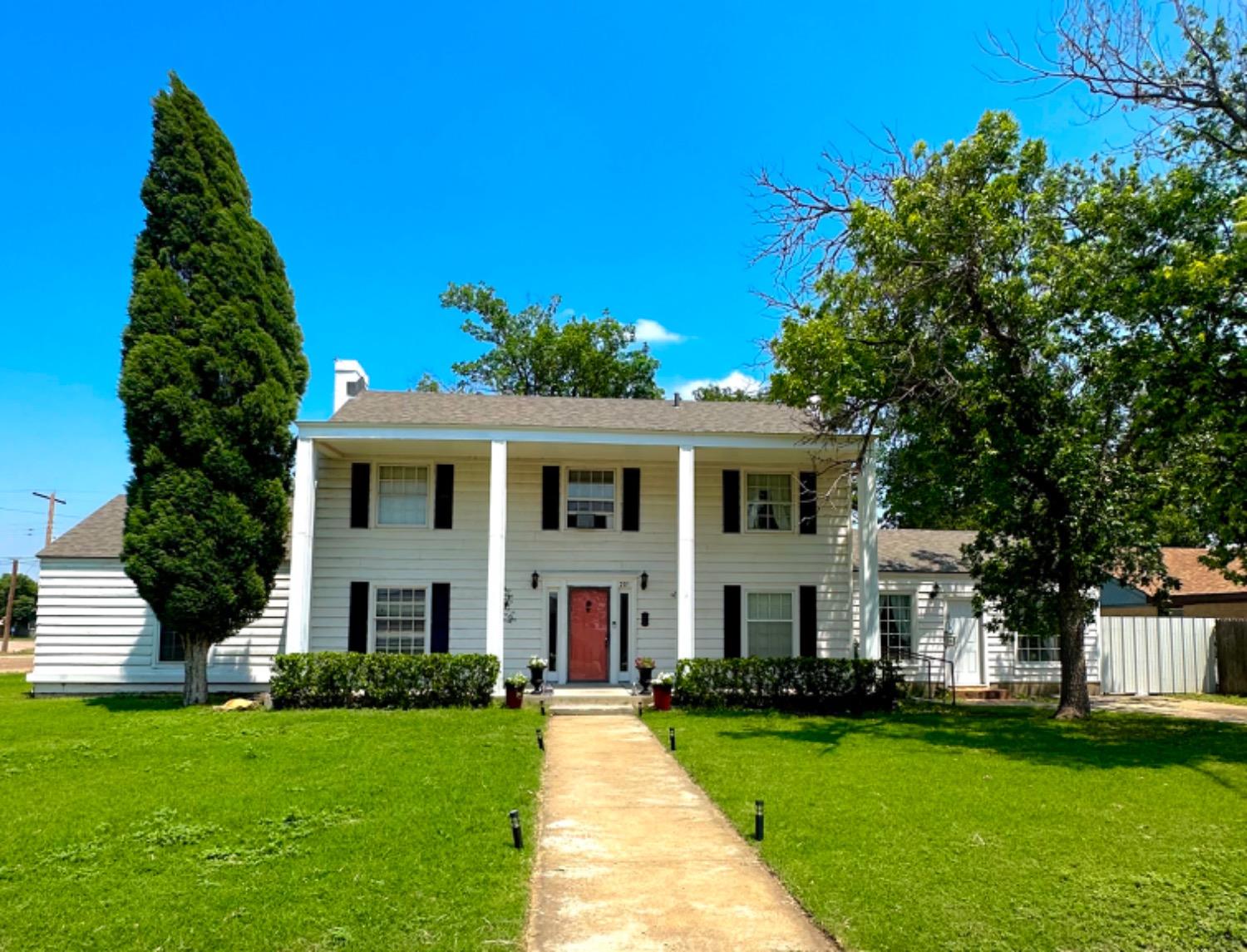 a view of a white house with a yard