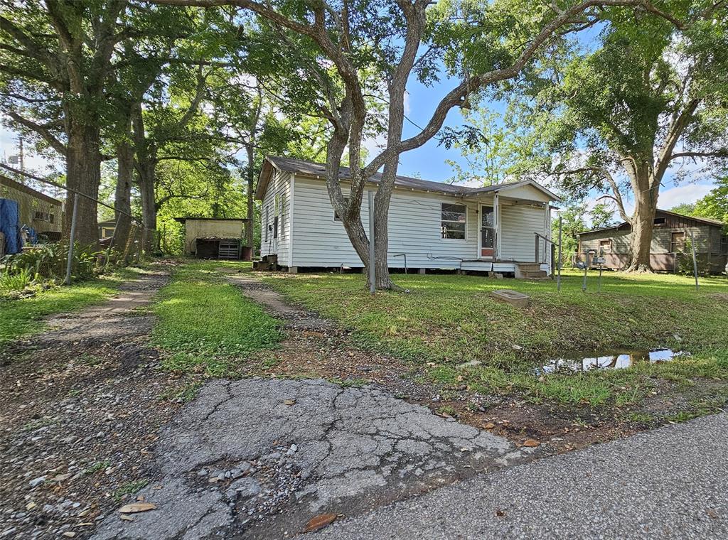 a view of a yard in front of a house with large trees