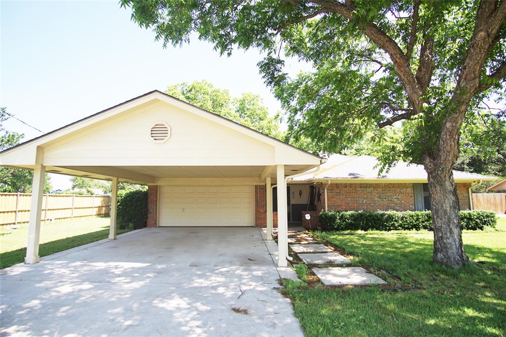 a view of a house with backyard and a tree