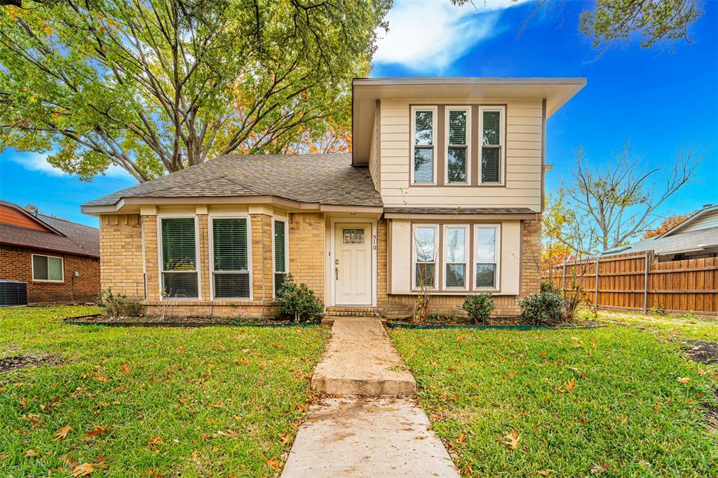 front view of a brick house with a yard