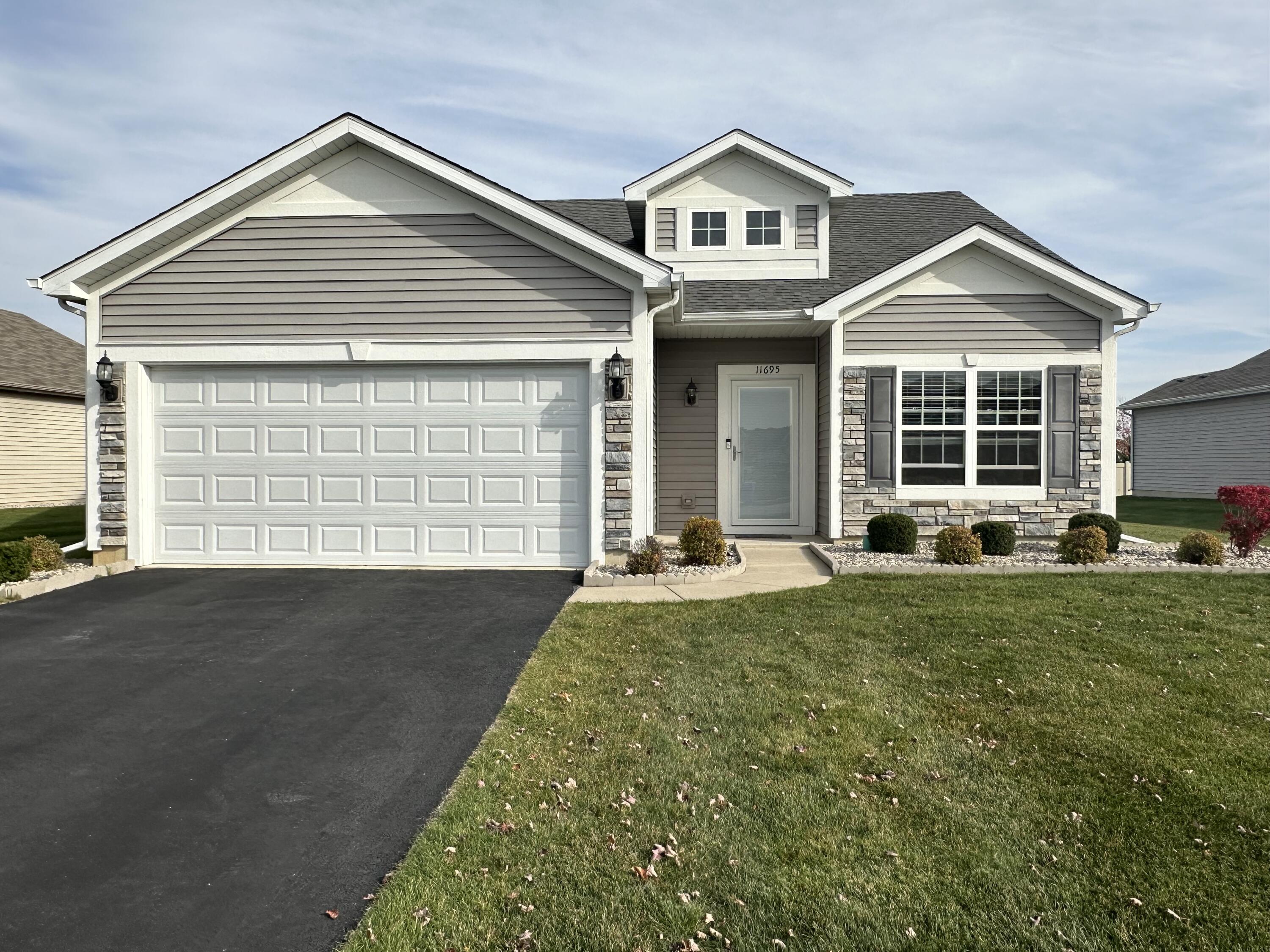 a front view of a house with a yard and garage