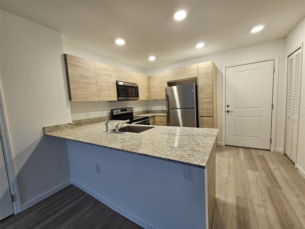 a kitchen with kitchen island sink refrigerator and microwave