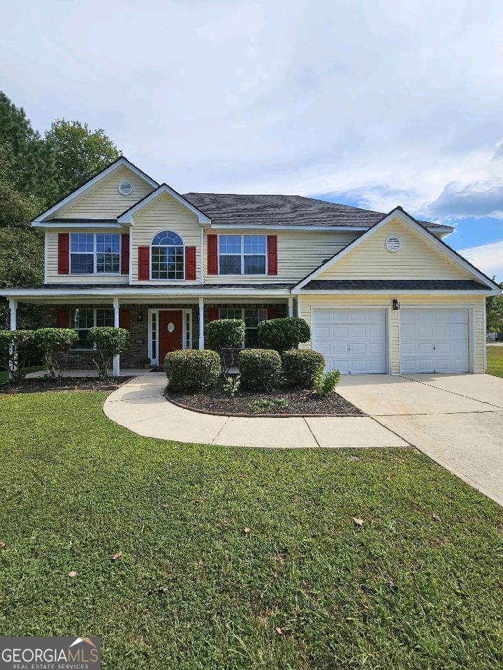 a front view of a house with a yard and garage