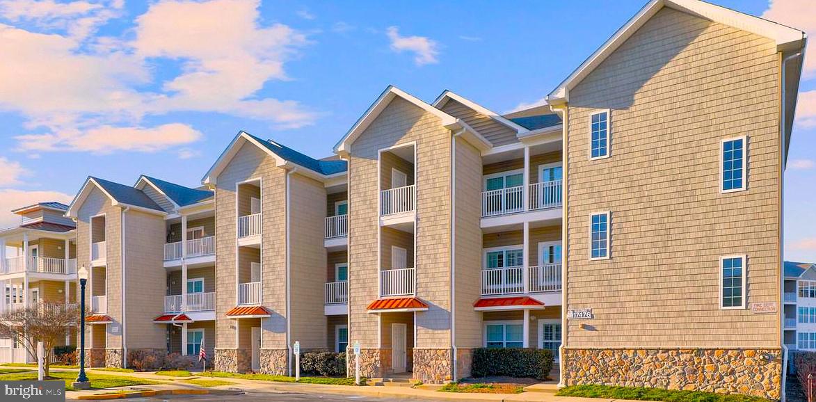 a front view of a residential apartment building with a yard