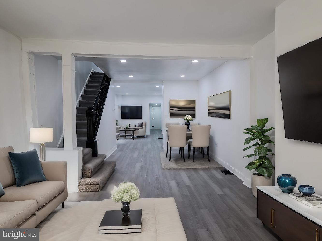 a living room with furniture potted plant and flat screen tv