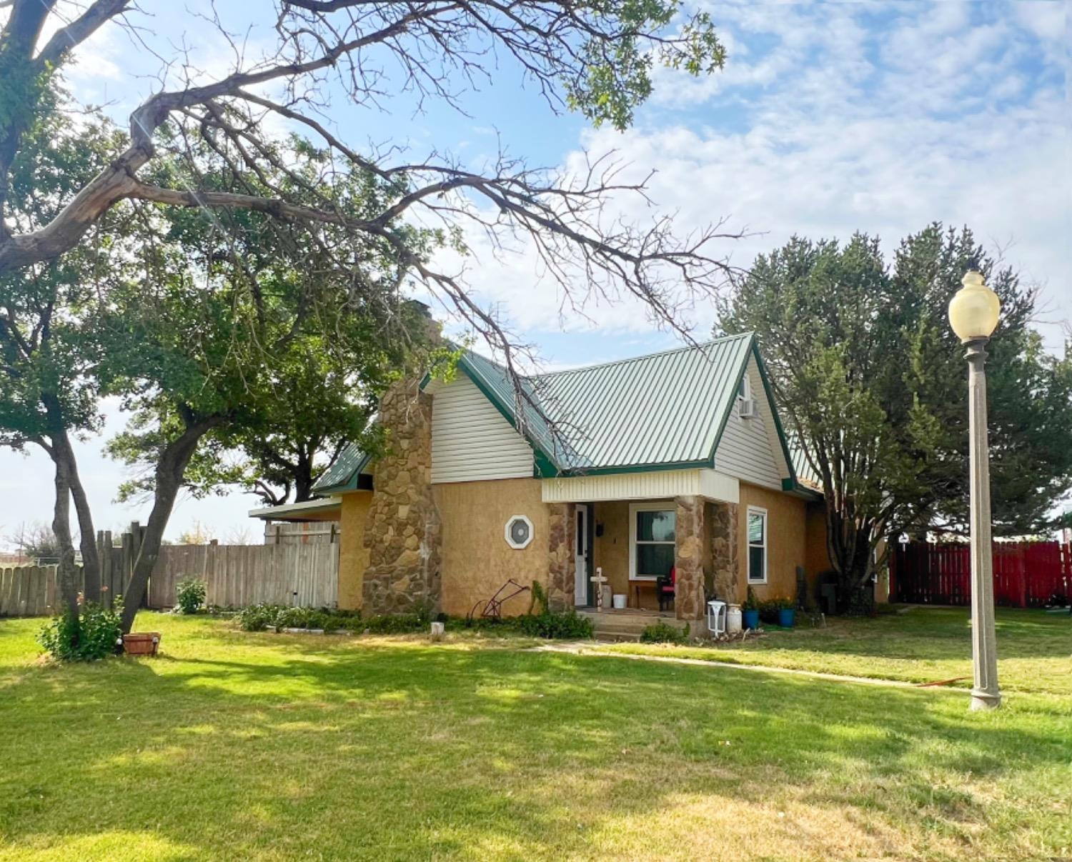 a front view of a house with a garden and trees