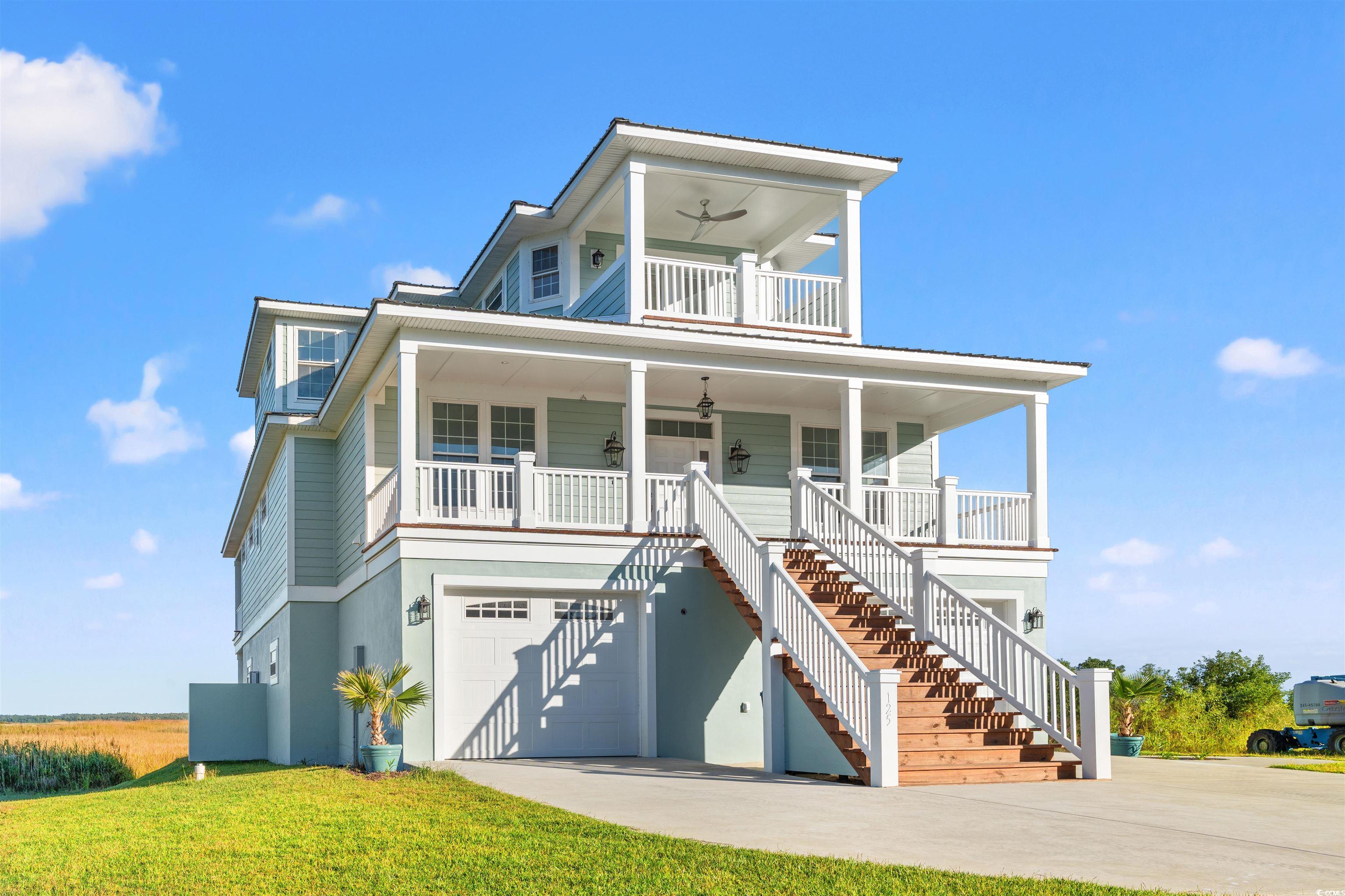 Raised beach house featuring ceiling fan, a garage