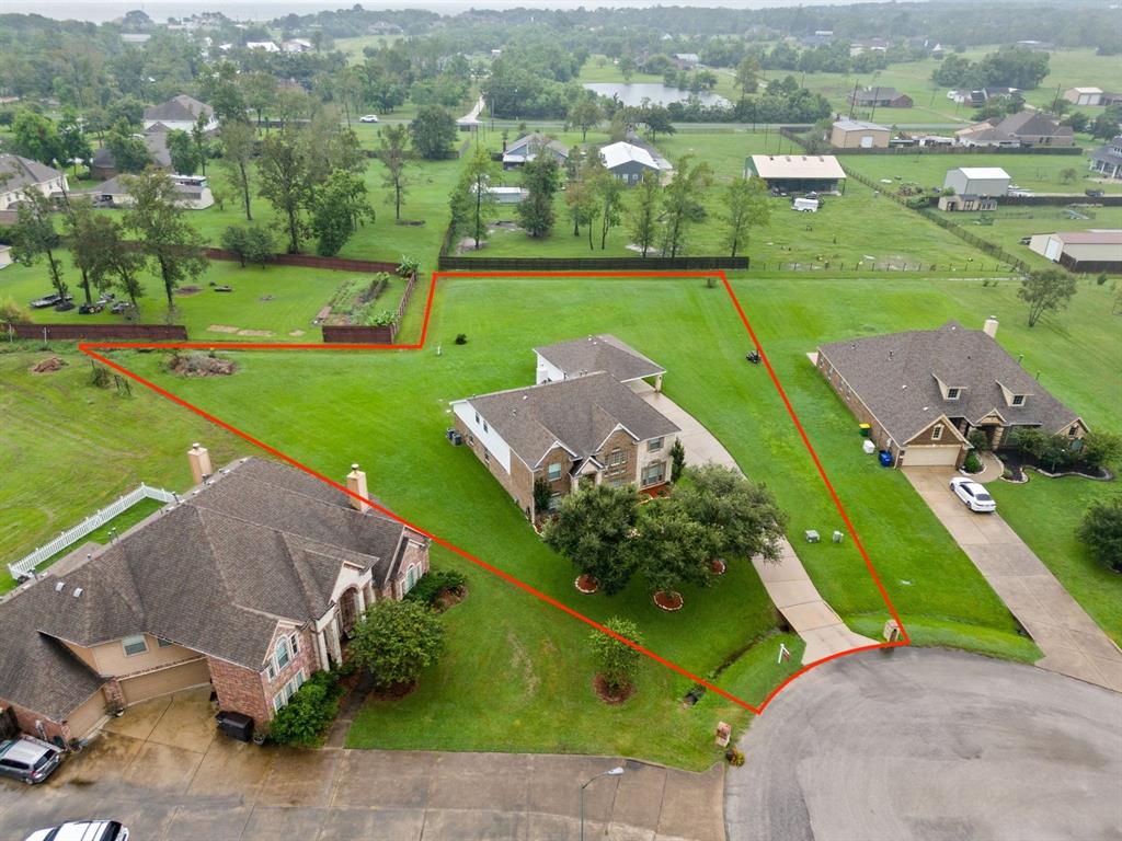 an aerial view of a house with a garden and lake view