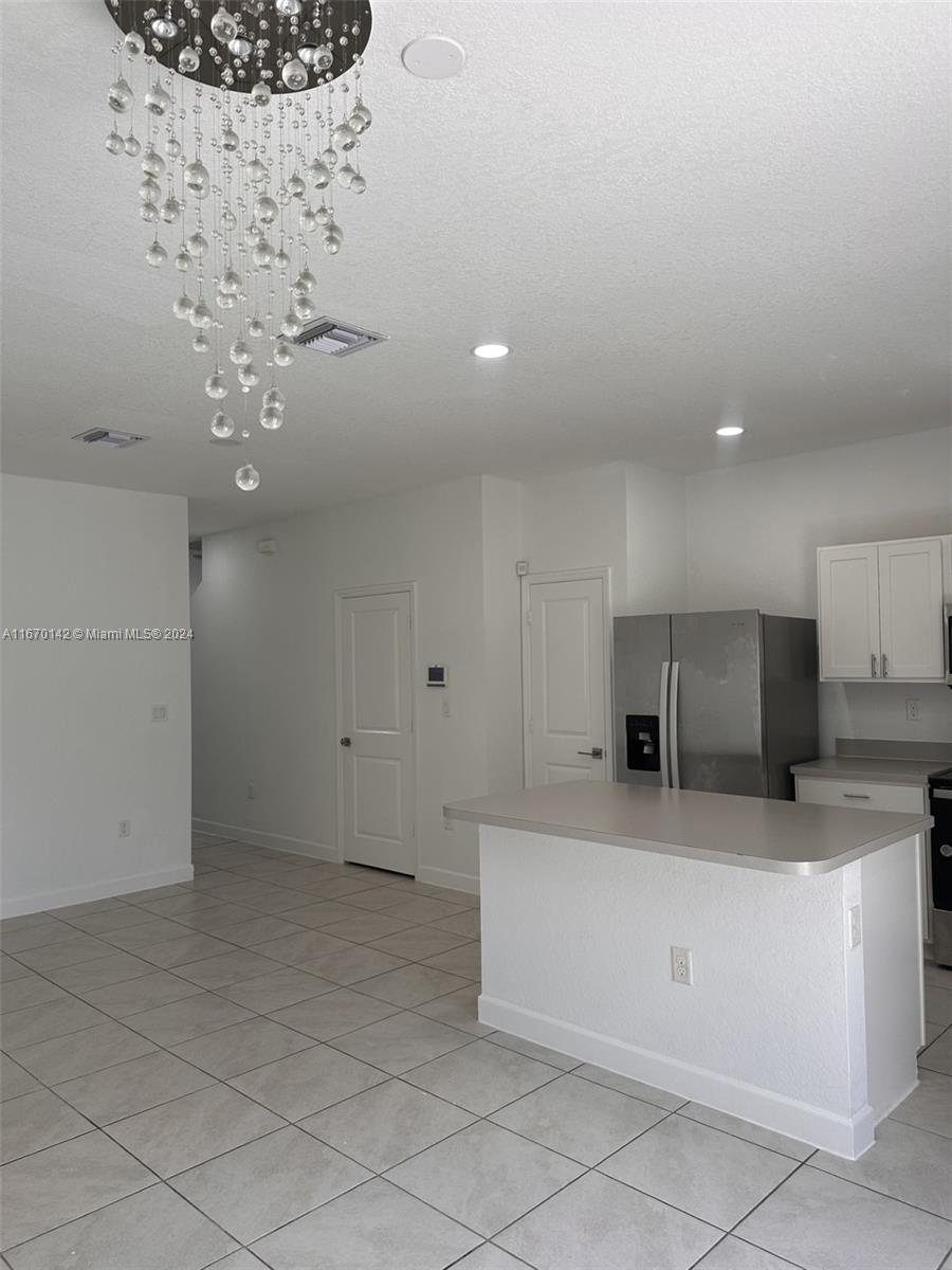 a large white kitchen with a cabinetry and stainless steel appliances