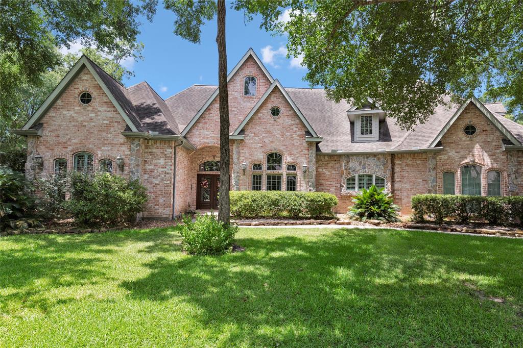 a front view of a house with a yard and trees