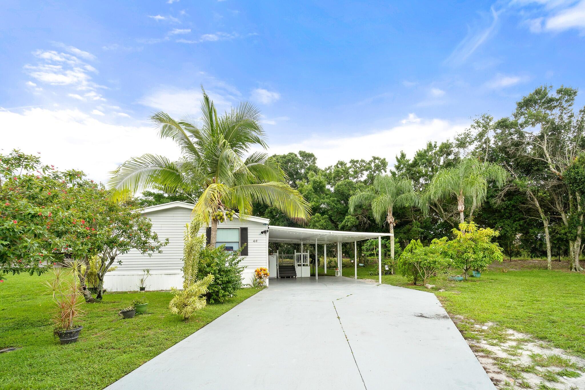 a view of a house with a yard and potted plants