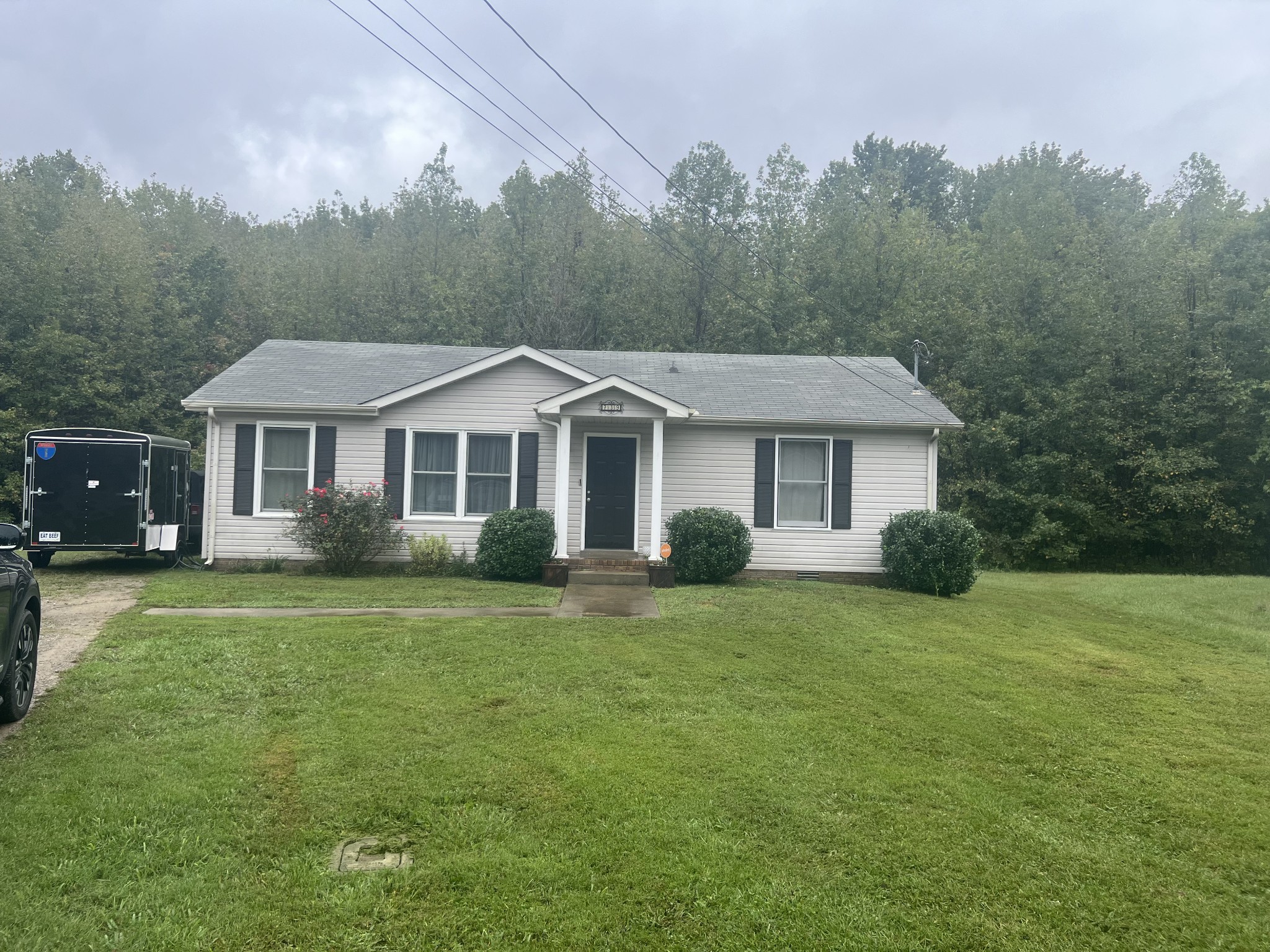 a front view of a house with a yard and trees