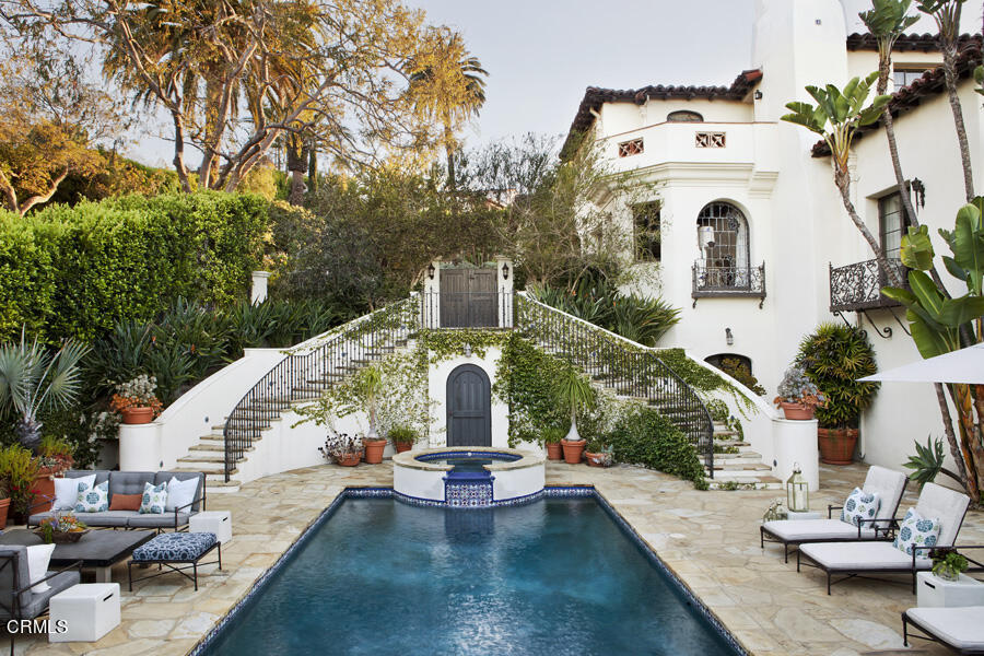 a view of a house with swimming pool and sitting area