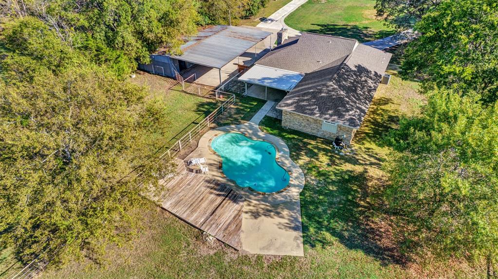 an aerial view of a house with a yard and large trees