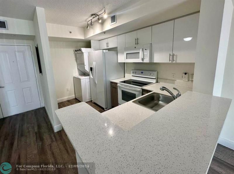 a kitchen with a sink a refrigerator and cabinets