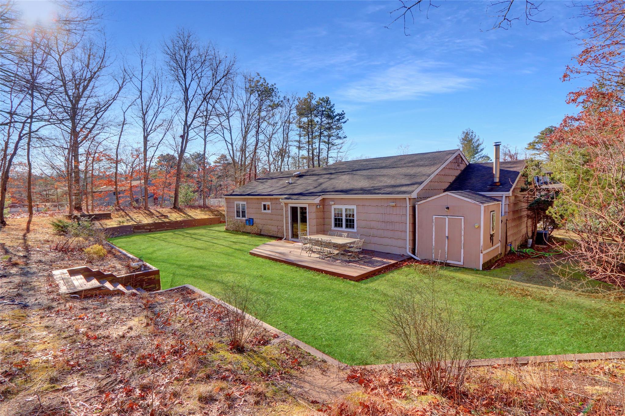 Back of house with a storage shed and a lawn