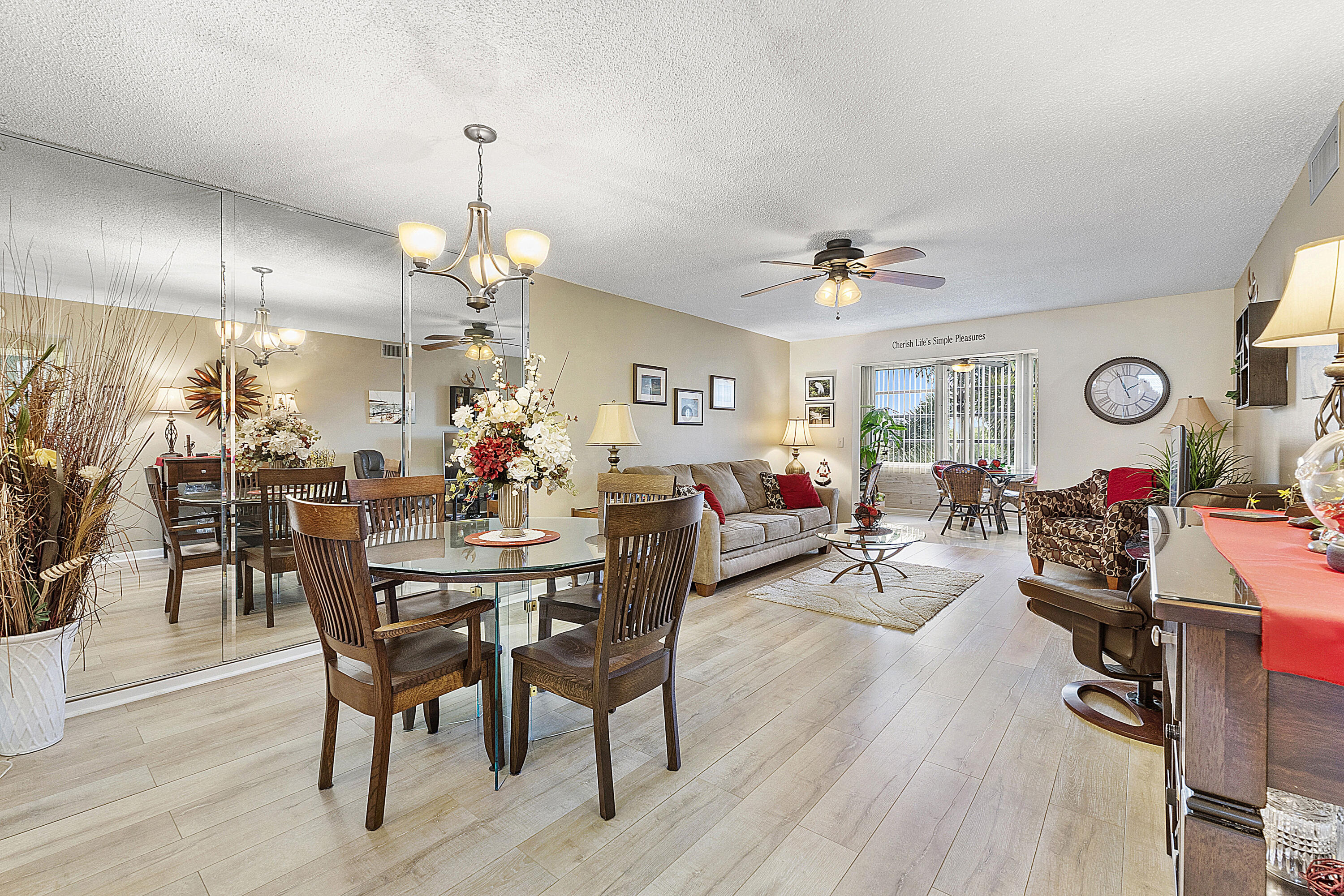 a view of a dining room and livingroom with furniture wooden floor a chandelier