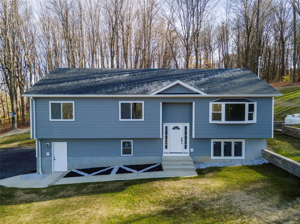 Split foyer home featuring a front lawn