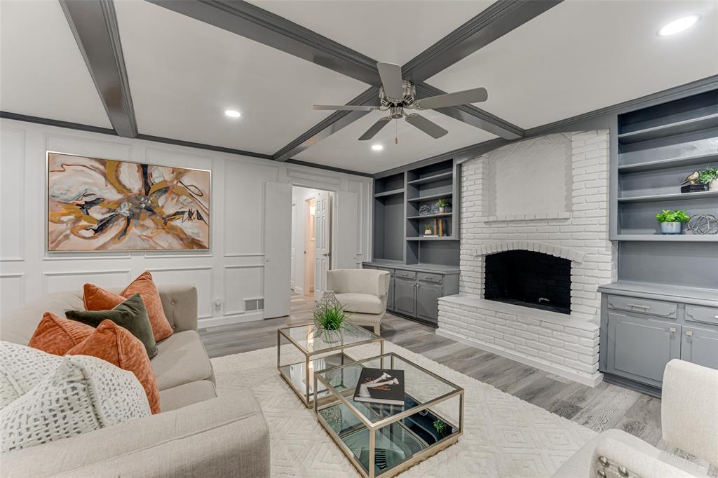 a living room with furniture a fireplace and a ceiling fan