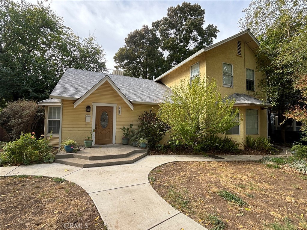 a front view of a house with a yard and trees